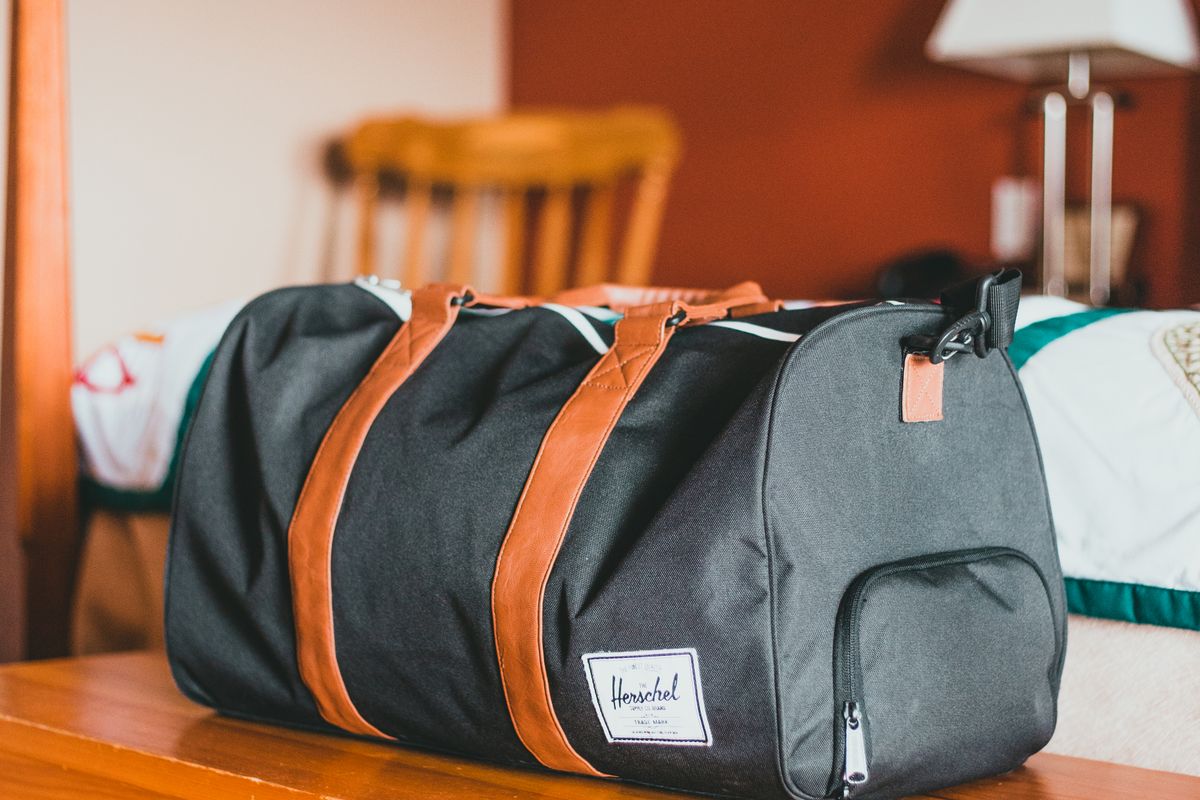 A 16-inch laptop being lowered into the padded sleeve of an open backpack