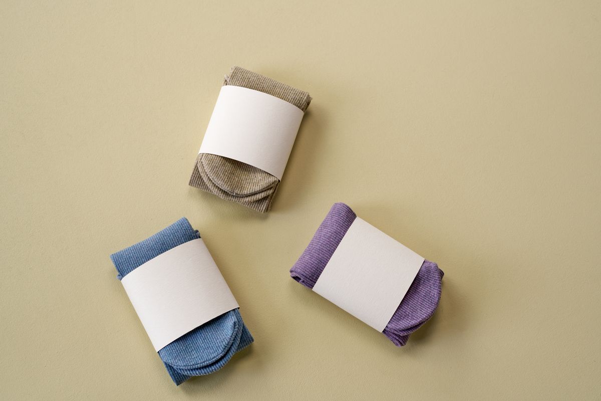 Four pairs of socks of increasing height arranged side by side on a wooden floor